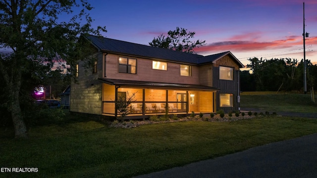 back house at dusk featuring a yard