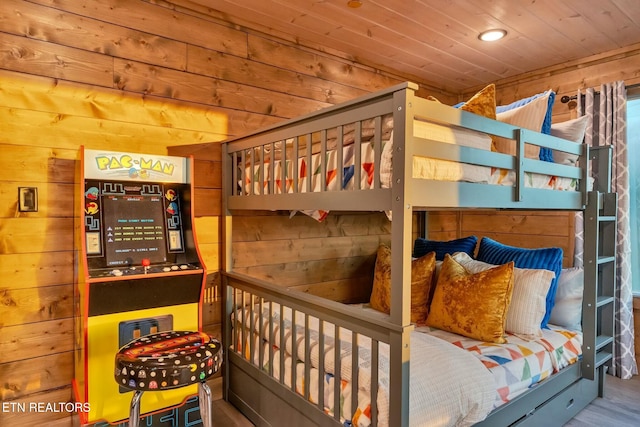 bedroom with wood ceiling and wood walls