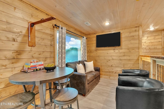 living room with wooden walls, light hardwood / wood-style flooring, and wooden ceiling