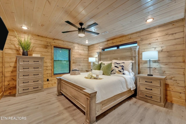 bedroom with wood ceiling, wooden walls, and light hardwood / wood-style floors