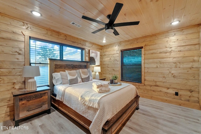 bedroom featuring wooden walls, wooden ceiling, and light hardwood / wood-style floors