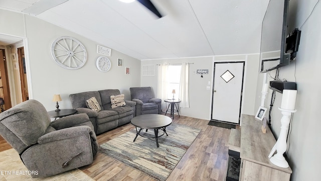 living room with lofted ceiling and light hardwood / wood-style flooring