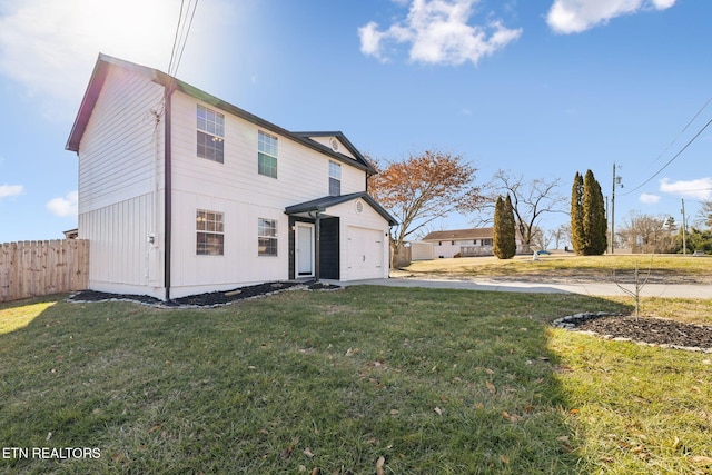 rear view of property featuring a yard and a garage