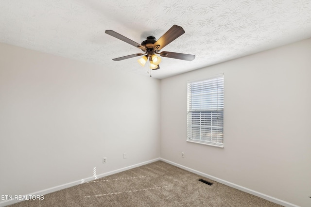 carpeted spare room featuring ceiling fan and a textured ceiling