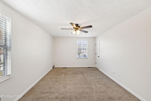 spare room with ceiling fan, carpet, and a textured ceiling