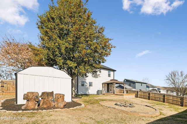 view of yard with central AC unit, a gazebo, and a storage unit