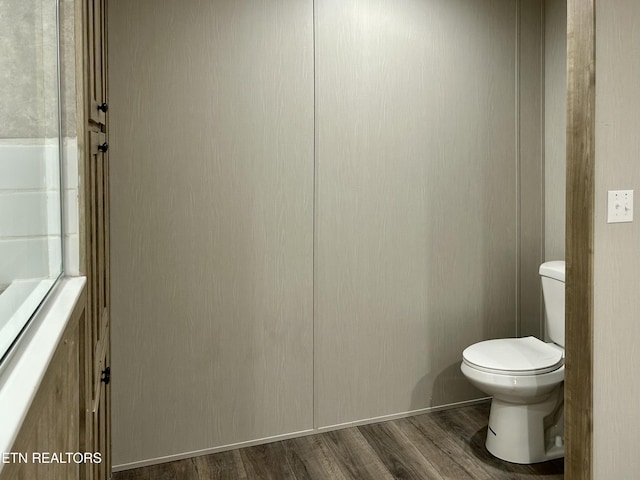 bathroom featuring hardwood / wood-style flooring and toilet