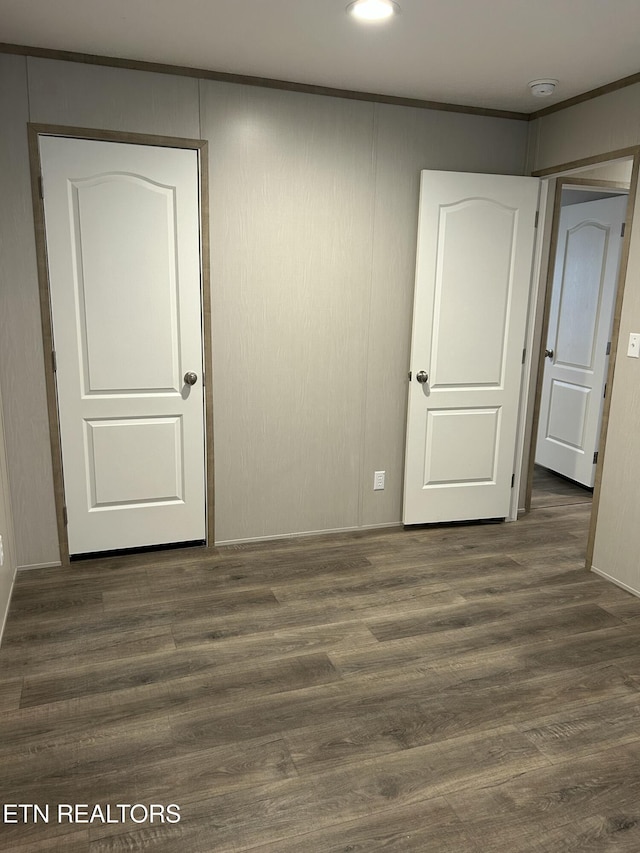 empty room with dark wood-type flooring and crown molding