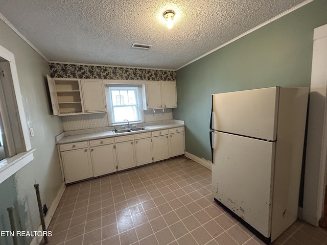 kitchen featuring sink, white cabinetry, tasteful backsplash, crown molding, and white fridge