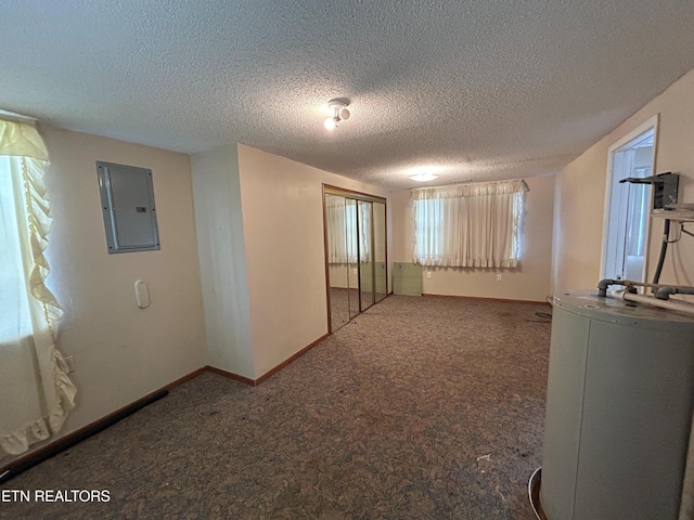 carpeted empty room with electric panel and a textured ceiling