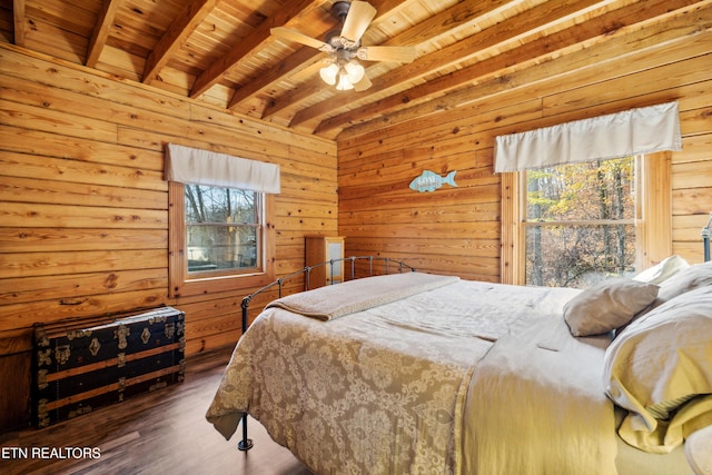 bedroom with wood ceiling, beam ceiling, dark hardwood / wood-style floors, and wood walls