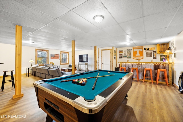 game room with indoor bar, a paneled ceiling, pool table, and light hardwood / wood-style flooring