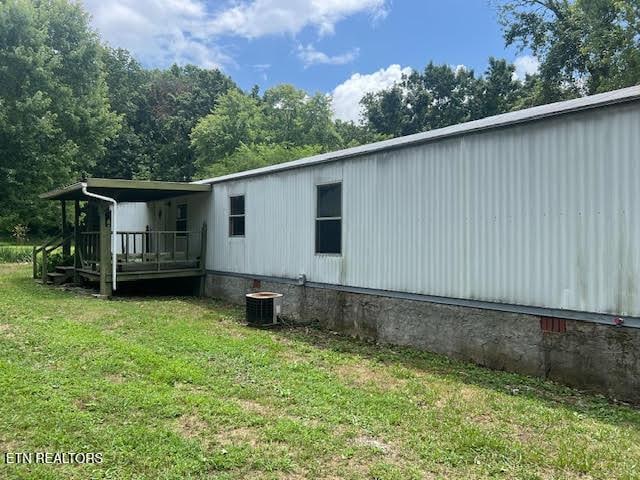 view of side of home featuring a yard and cooling unit