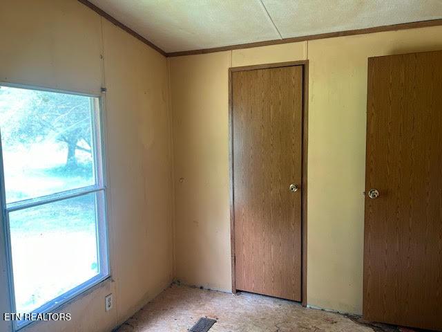 unfurnished bedroom featuring multiple windows and a closet