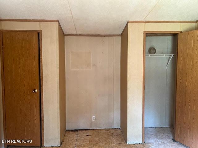 unfurnished bedroom with crown molding and a closet