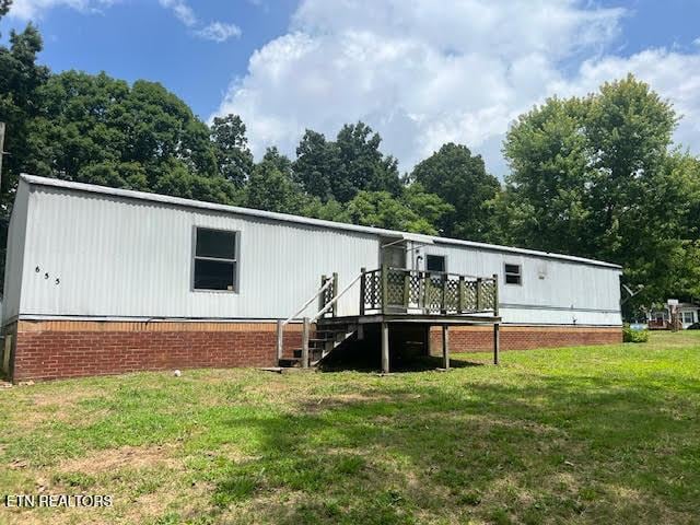 back of house featuring a wooden deck and a lawn