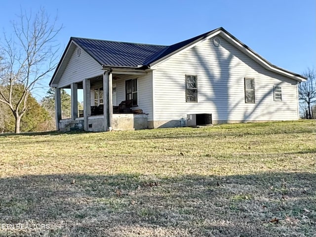 view of property exterior with covered porch and a lawn