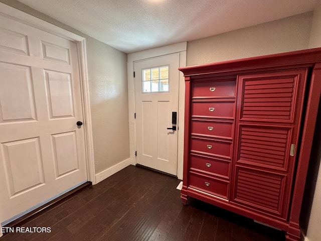 entryway with dark hardwood / wood-style flooring and a textured ceiling