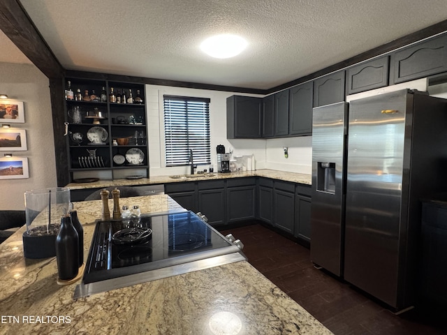 kitchen with cooktop, sink, stainless steel fridge with ice dispenser, dark hardwood / wood-style floors, and light stone countertops