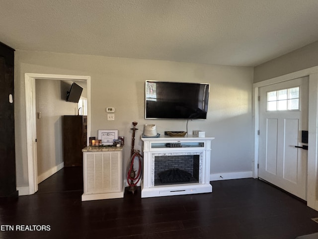 unfurnished living room with a textured ceiling and dark hardwood / wood-style flooring