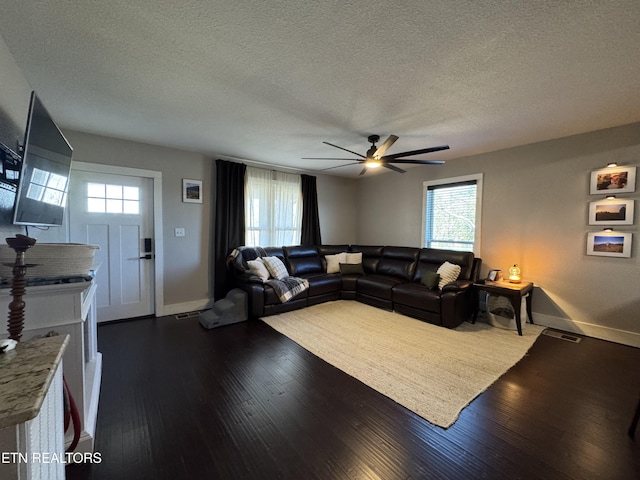 living room with ceiling fan, a textured ceiling, and dark hardwood / wood-style flooring