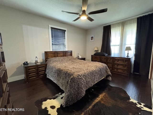 bedroom with a textured ceiling, dark hardwood / wood-style floors, and ceiling fan