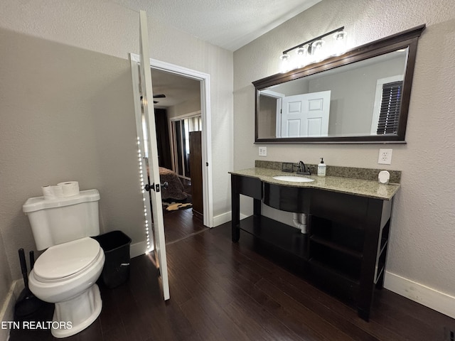 bathroom with hardwood / wood-style flooring, vanity, and toilet