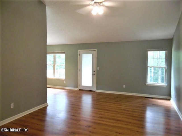 interior space featuring ceiling fan, lofted ceiling, and dark hardwood / wood-style flooring