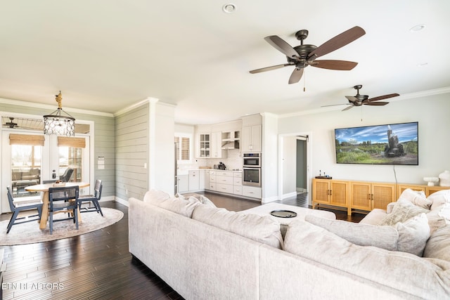 living room with crown molding, dark hardwood / wood-style flooring, and a notable chandelier