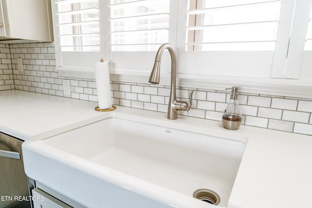 room details with white cabinetry, sink, and decorative backsplash