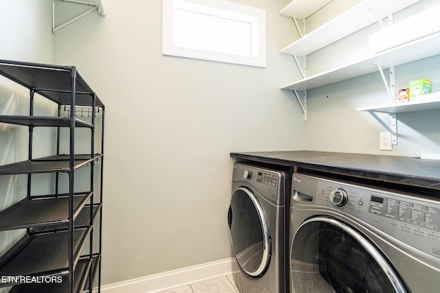 washroom featuring washing machine and dryer and light tile patterned floors