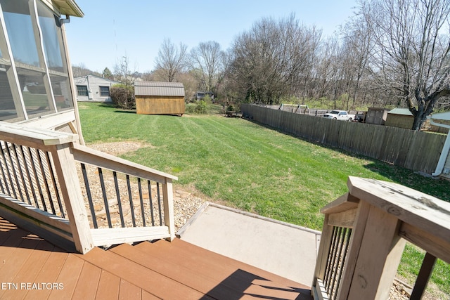 view of yard featuring a wooden deck and a storage unit