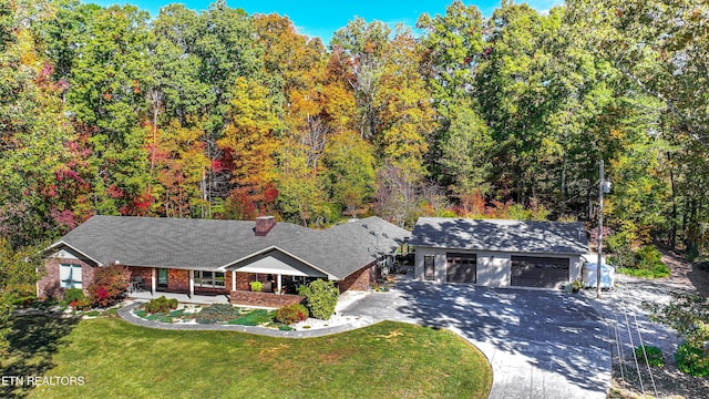 view of front of property featuring covered porch, brick siding, a front yard, and a garage