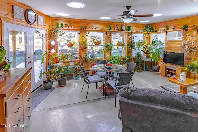 sunroom / solarium featuring a wealth of natural light, an AC wall unit, ceiling fan, and french doors