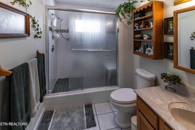 bathroom featuring a stall shower, vanity, toilet, and tile patterned floors