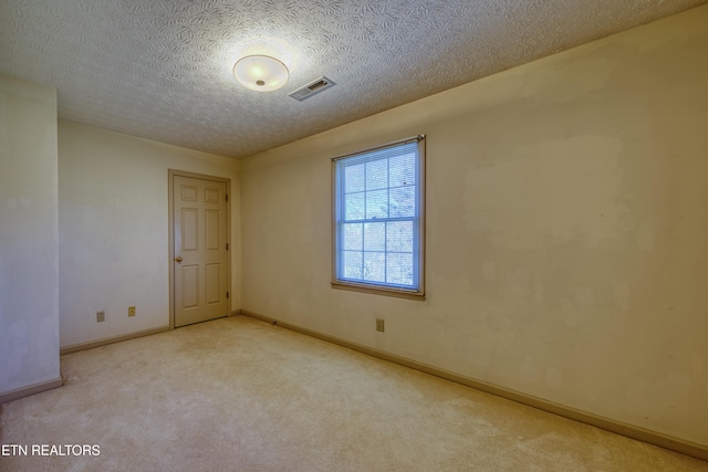 carpeted spare room with a textured ceiling