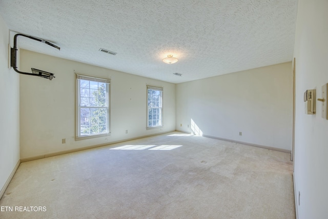 carpeted empty room featuring a textured ceiling