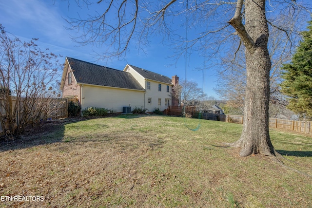 view of side of home with central AC and a lawn