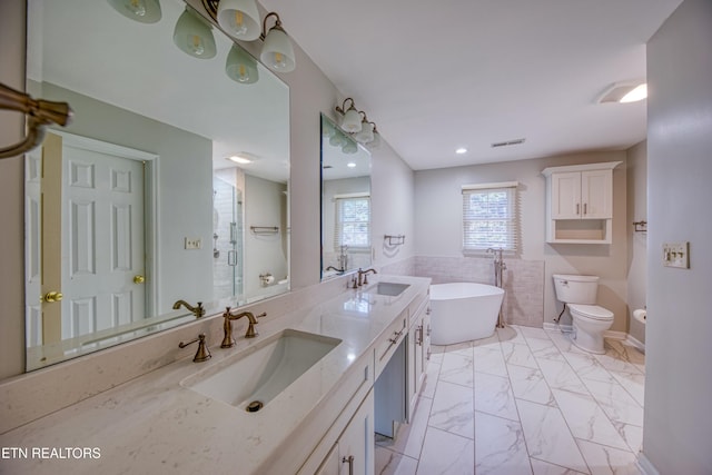 full bathroom with independent shower and bath, vanity, tile walls, and toilet