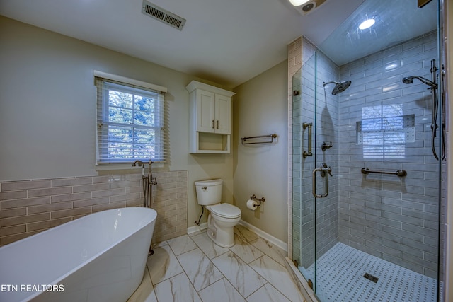 bathroom featuring tile walls, plus walk in shower, and toilet