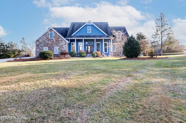 view of front of home with stone siding and a front lawn