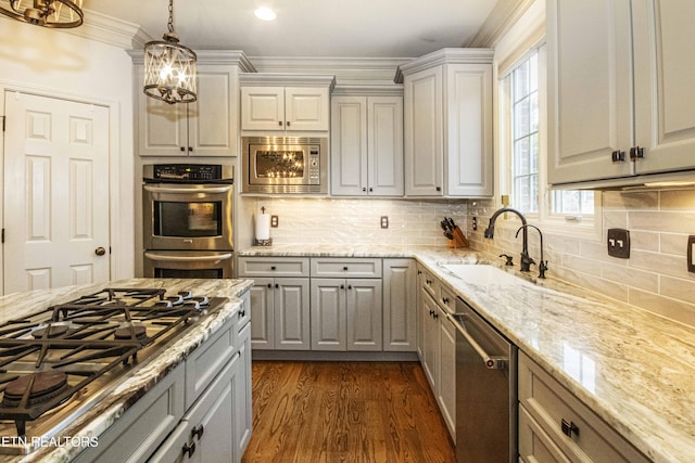 kitchen featuring pendant lighting, sink, gray cabinets, stainless steel appliances, and dark hardwood / wood-style flooring