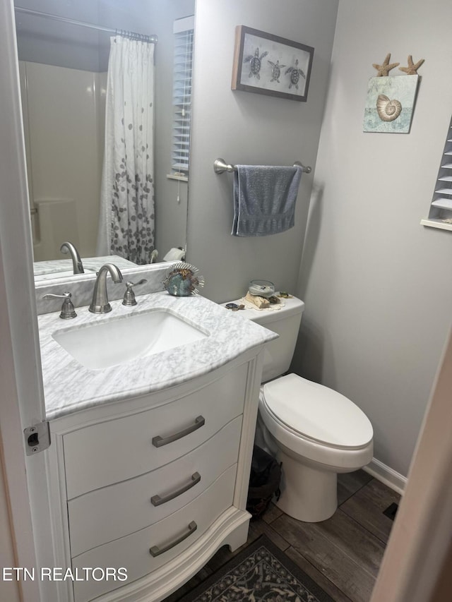 bathroom with a shower with curtain, vanity, hardwood / wood-style floors, and toilet