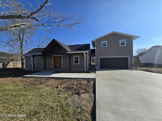 view of front of property with a garage, concrete driveway, and fence