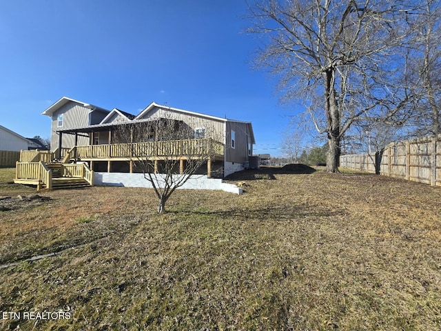 back of house featuring a yard, fence, and a deck