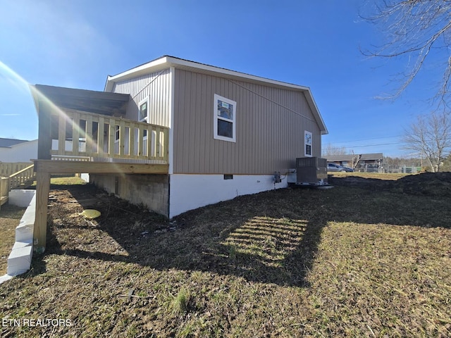 view of side of property with crawl space, central AC, and a wooden deck