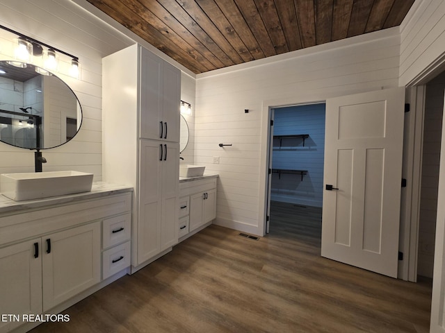 bathroom with double vanity, wooden ceiling, a sink, and wood finished floors