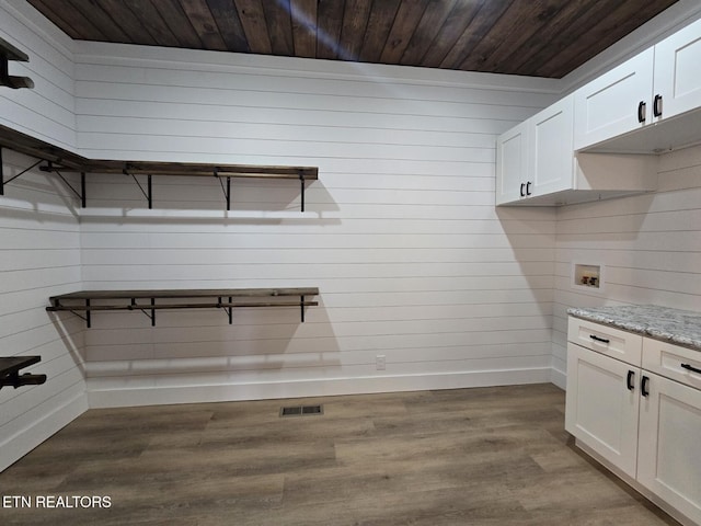 interior space featuring baseboards, visible vents, wooden ceiling, wood finished floors, and hookup for a washing machine