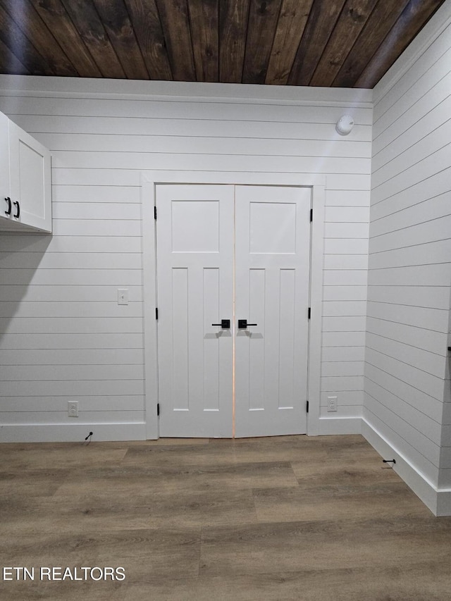 interior space with wooden ceiling, wood finished floors, and wooden walls