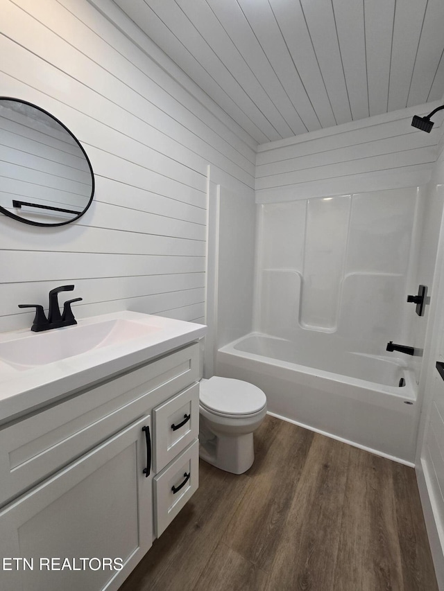 full bath featuring shower / bath combination, toilet, wooden ceiling, wood finished floors, and vanity